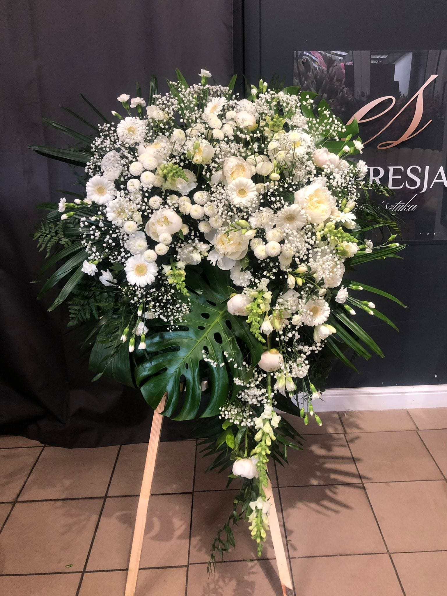 Wieniec z kwiatów żywych białe kwiaty z liściem monstery