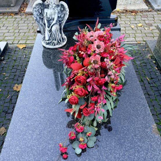 Kompozycja nagrobna z delikatną czerwoną różyczką gałązkową Kompozycja nagrobna z delikatną czerwoną różyczką gałązkową